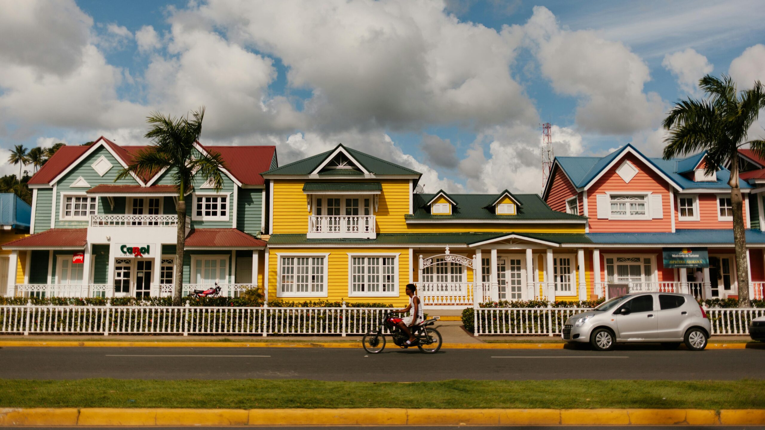 A vibrant street view of colorful wooden houses under a clear blue sky in a small town.
